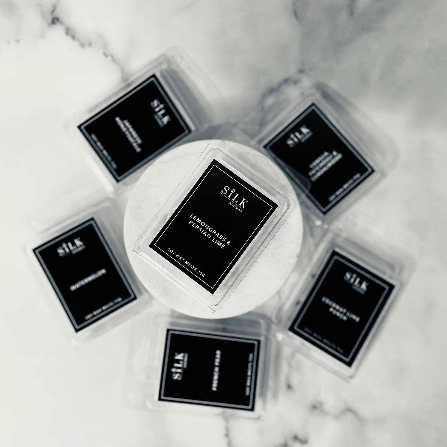 A collection of wax melt packages with black labels